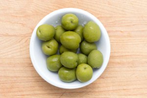 Small white plate of whole Castelvetrano Olives