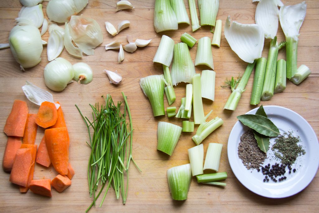 Mirepoix vegetable stock carrots, onions, celery, fennel, garlic and dried spices on a large cutting board