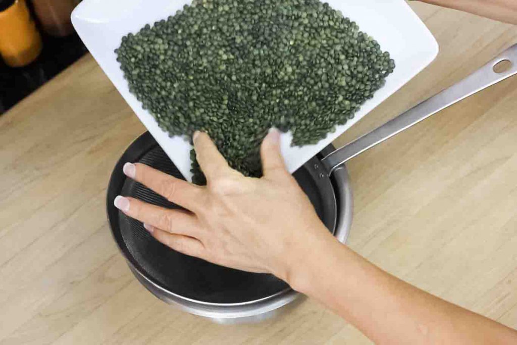 Sorting Lentils: Directing the lentils into the strainer by pinching from side to side with your fingers.