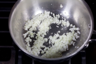 Saucier pan with onions sauteeing until starting to turn translucent