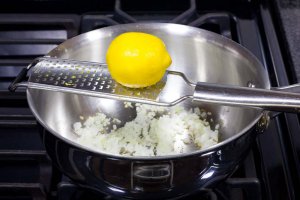 Zest the yellow part of the lemon skin with a microplane grater right into the pan with the onions. Zest the yellow part of the lemon skin with a micro-plane grater right into the pan with the onions.