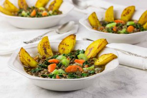 3 white bowls of Mirepoix Mirepoix lentil soup with vibrant vegetables andwith roasted potatoes