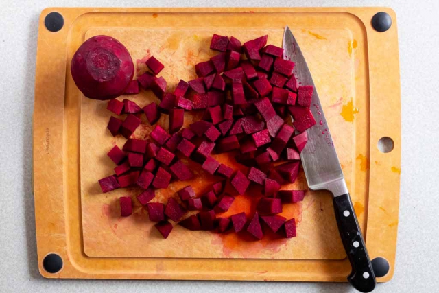 Diced beets on a cutting board with a chef knife